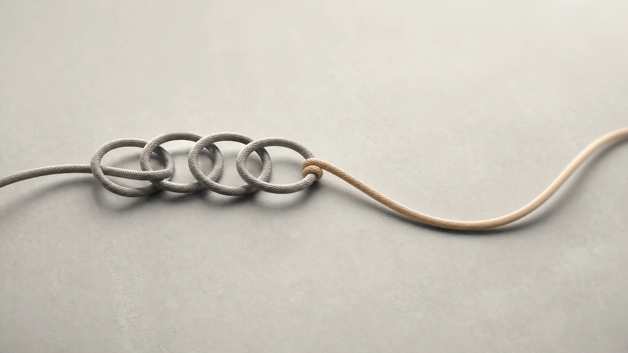 A tangled loop of cord repeats on itself before one strand breaks free into a looser, open path, set against a soft neutral background.